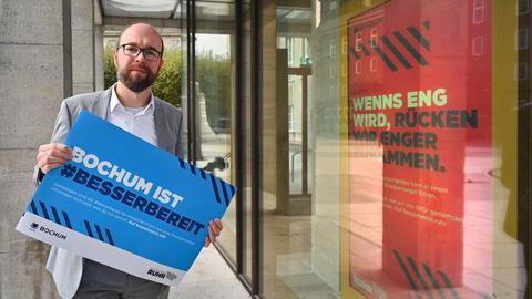 Dezernent Sebastian Kopietz mit einem Plakat der Kampagne #besserbereit am 13.10.2022 vor dem Rathaus in Bochum.