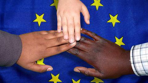 Hände auf einer Europaflagge