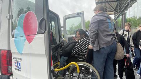Ein Rollstuhlfahrer wird in einen Bully geladen