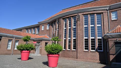 Der Innenhof des Gebäudes der Alten Lohnhalle inklusive des Eingangs. Vor dem Gebäude sind Pflanzenkübel.