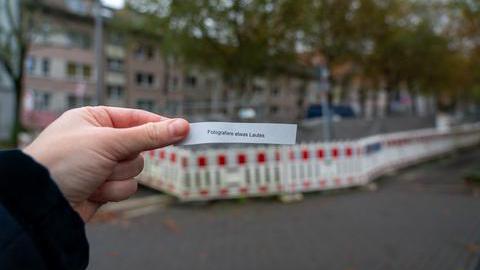 Zettel mit der Aufschrift "Fotografiere etwas Lautes", im Hintergrund eine Baustelle